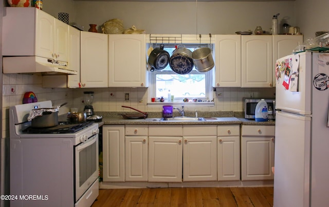 kitchen featuring white cabinets, white appliances, light hardwood / wood-style floors, sink, and tasteful backsplash