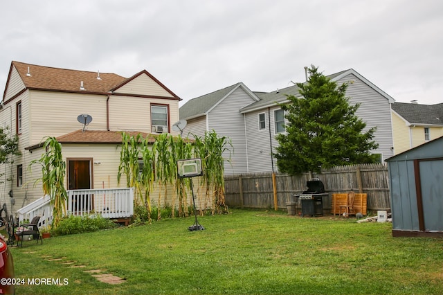 view of yard with a storage shed, an outbuilding, and fence