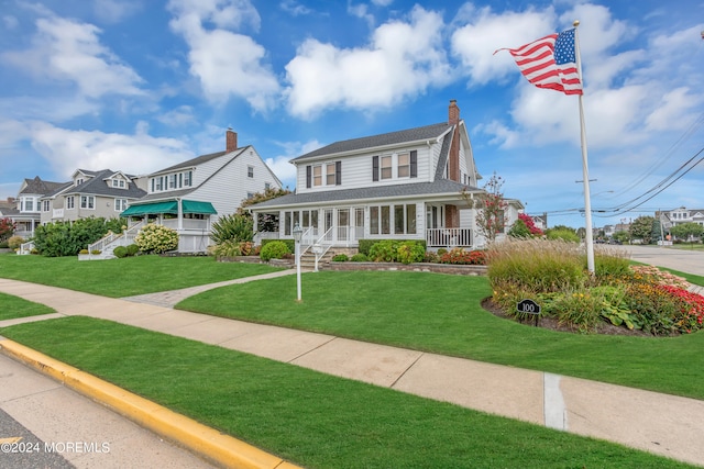 farmhouse-style home featuring a front lawn and covered porch