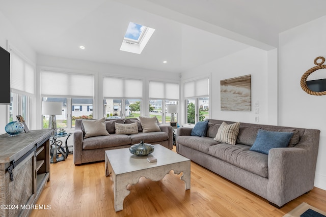 living room featuring light hardwood / wood-style floors and lofted ceiling with skylight