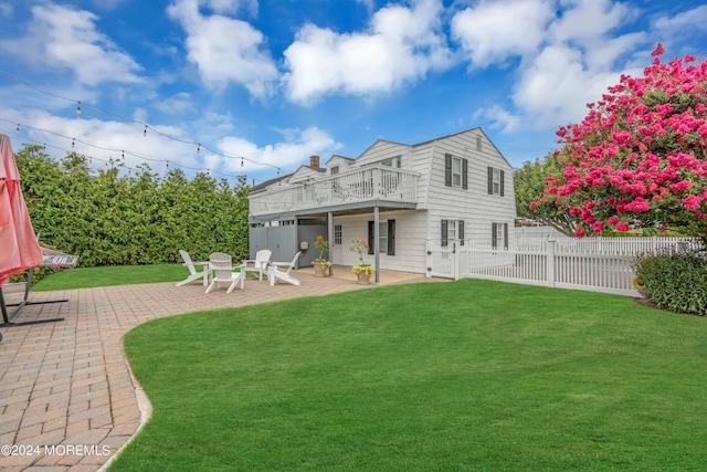 back of property with a yard and a patio