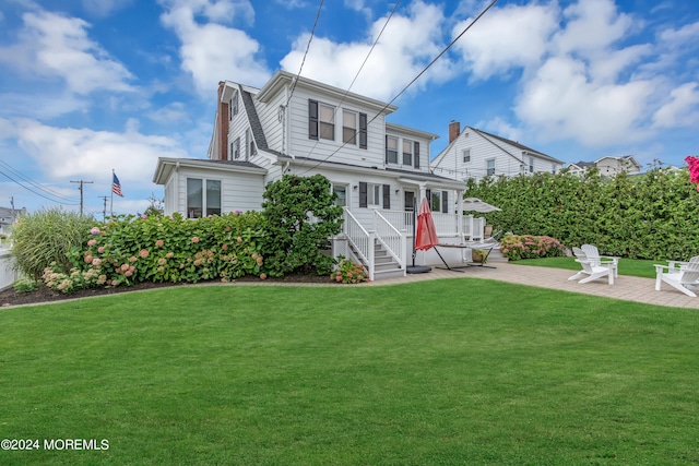 view of front of property with a patio and a front yard