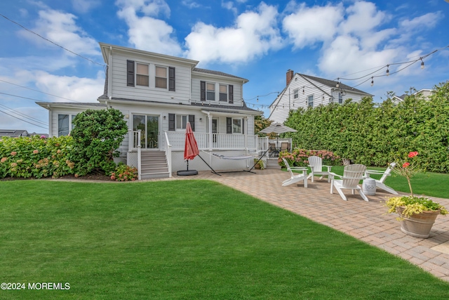 exterior space featuring a yard, a patio, and a hot tub