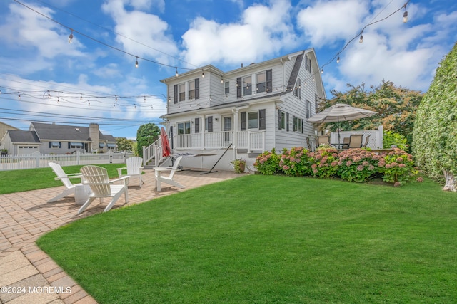 view of front of property with an outdoor fire pit, a front lawn, and a patio