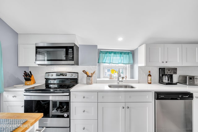 kitchen featuring sink, stainless steel appliances, white cabinets, and decorative backsplash