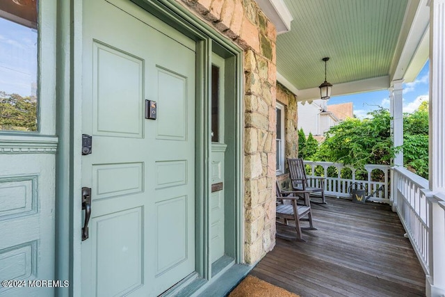 property entrance with covered porch and stucco siding