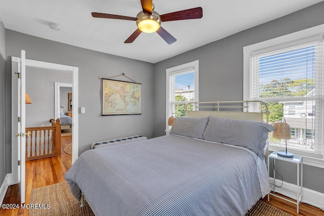 bedroom with ceiling fan, baseboards, and wood finished floors