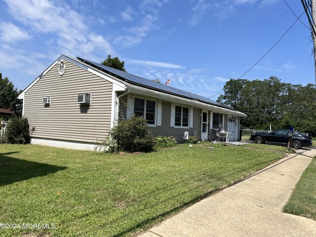 view of front of house with a front yard and solar panels