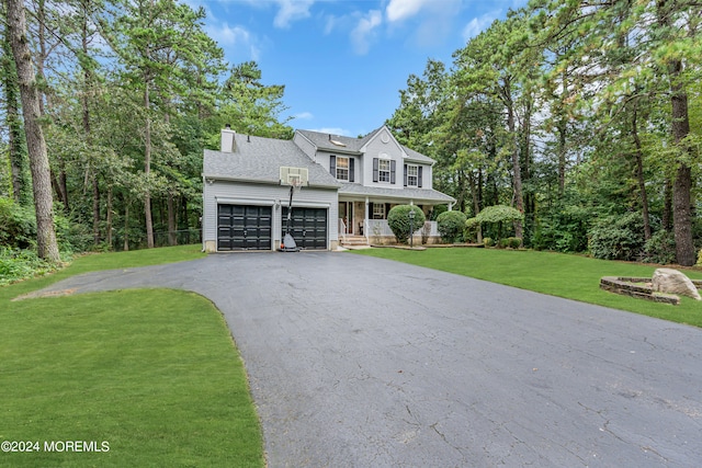 view of front of property with covered porch, a front yard, and a garage