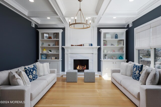 living room with coffered ceiling, a premium fireplace, beam ceiling, a chandelier, and light wood-type flooring