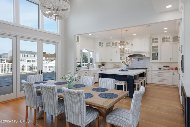 dining area with a healthy amount of sunlight, a notable chandelier, and light hardwood / wood-style flooring