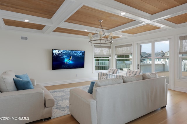 living room with coffered ceiling, plenty of natural light, and a notable chandelier