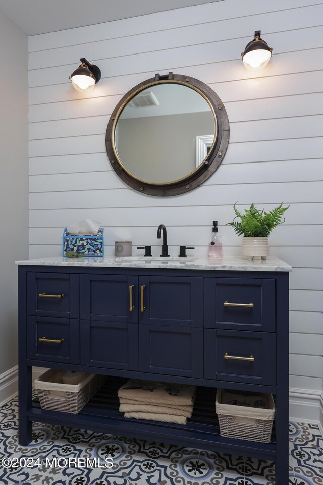 bathroom with vanity and wood walls