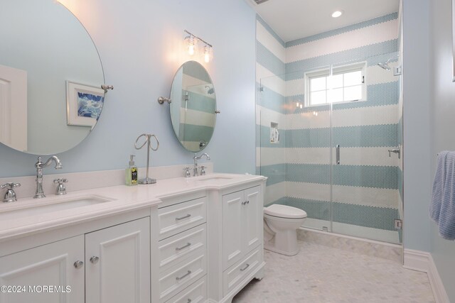 bathroom featuring vanity, toilet, and an enclosed shower