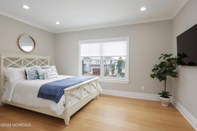 bedroom with crown molding and light hardwood / wood-style flooring