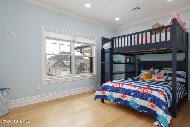 bedroom with light hardwood / wood-style flooring and ornamental molding