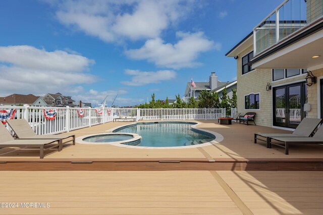 view of pool featuring an in ground hot tub and a deck