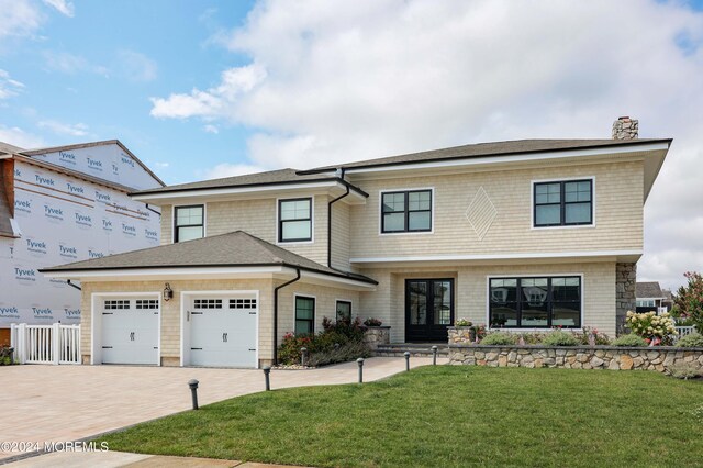 view of front of house featuring a garage and a front lawn