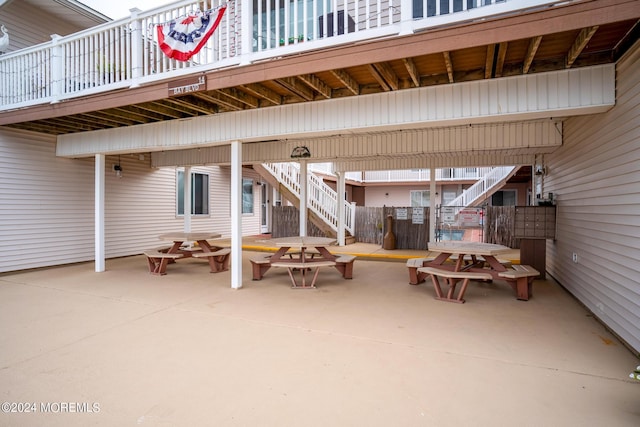 view of patio with outdoor dining area and stairs