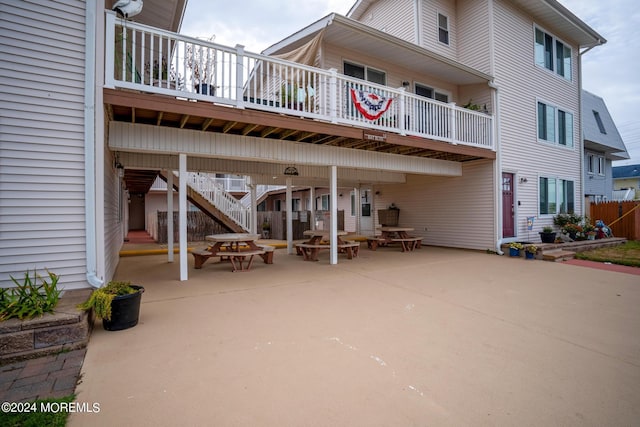 rear view of house featuring a patio area and stairway