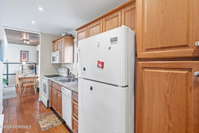 kitchen featuring white appliances, recessed lighting, a sink, light countertops, and wood-type flooring