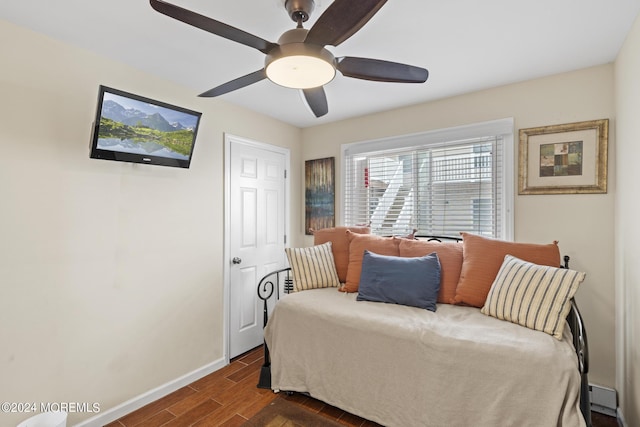 bedroom with dark wood-type flooring, a ceiling fan, and baseboards