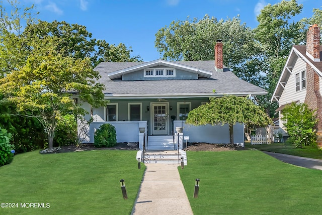 view of front of home with a front yard and covered porch