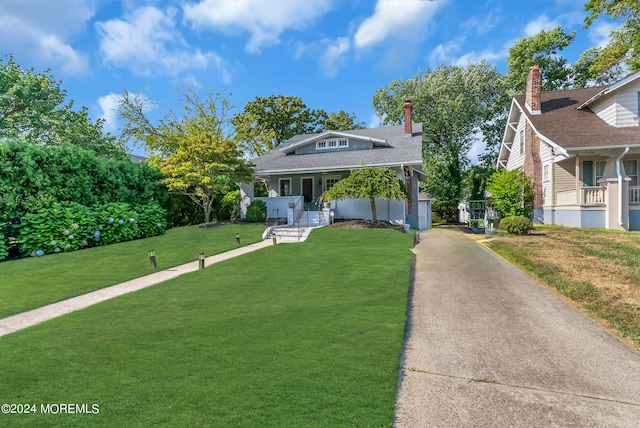 view of front of home with covered porch and a front lawn