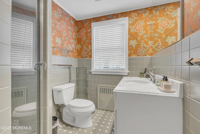 bathroom featuring radiator, vanity, tile walls, and toilet