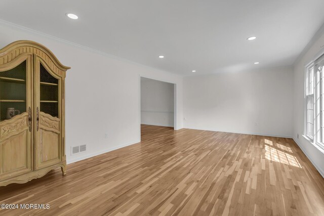 unfurnished room featuring crown molding and hardwood / wood-style flooring