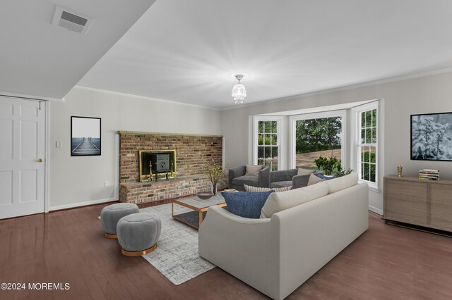 living room with wood-type flooring, crown molding, and a brick fireplace