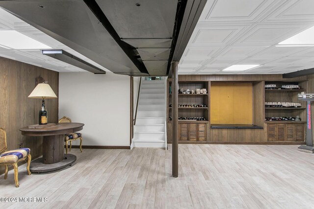 basement featuring wood walls and wood-type flooring