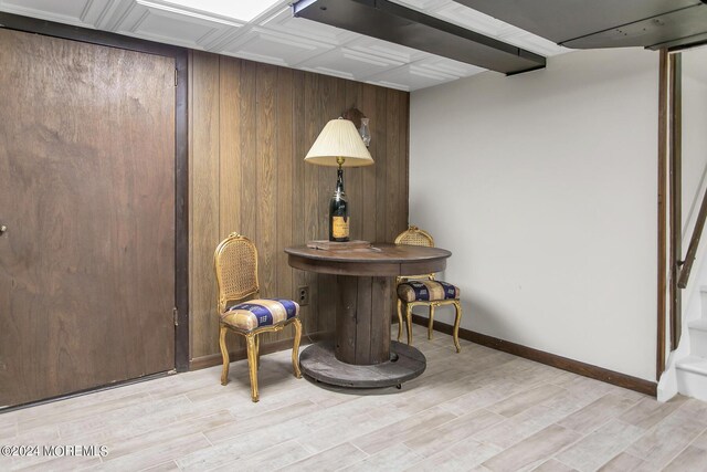 living area featuring wood walls and light hardwood / wood-style floors