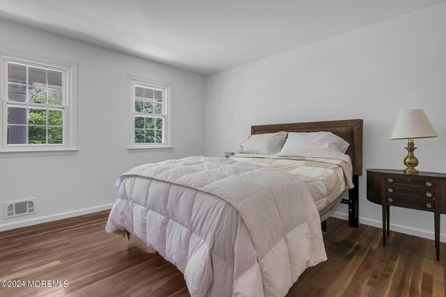 bedroom with dark hardwood / wood-style flooring