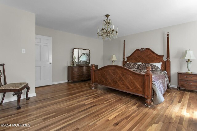 bedroom featuring dark wood-type flooring and a notable chandelier