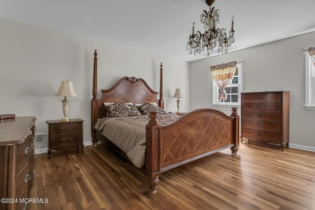 bedroom featuring dark wood-type flooring and an inviting chandelier