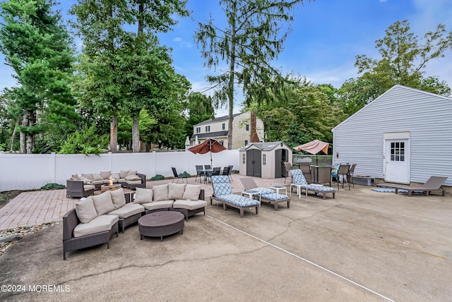 view of patio / terrace with an outbuilding, a fenced backyard, a storage shed, outdoor lounge area, and outdoor dining space