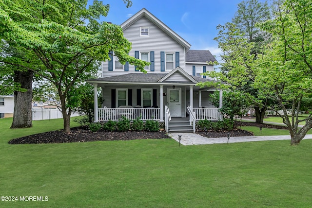 view of front of house featuring a front lawn, a porch, and a shingled roof