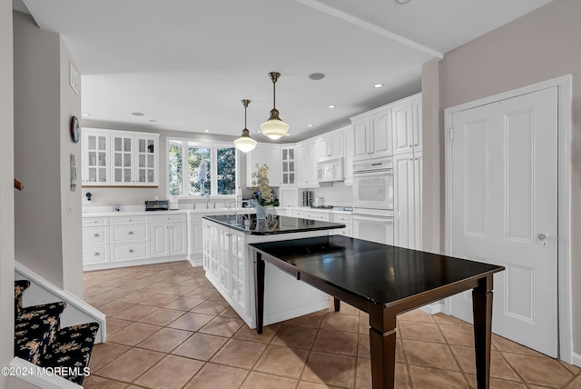 kitchen with glass insert cabinets, white appliances, white cabinetry, and light tile patterned flooring