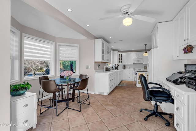 kitchen featuring light countertops, white appliances, light tile patterned flooring, and white cabinetry