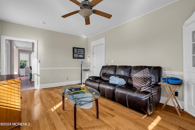 living room featuring light wood finished floors, ceiling fan, and baseboards