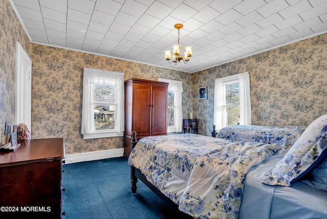 bedroom with wallpapered walls, baseboards, dark carpet, and a chandelier