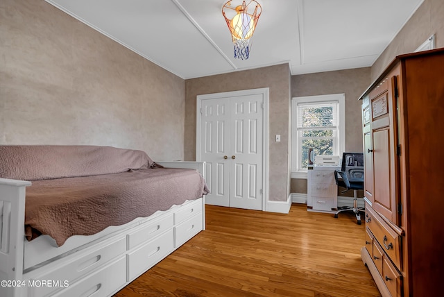 bedroom featuring a closet, light wood-type flooring, and baseboards