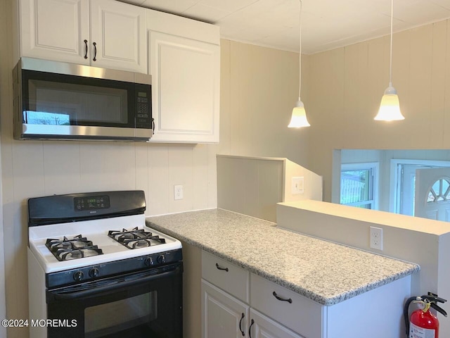 kitchen featuring gas range gas stove, decorative light fixtures, and white cabinetry