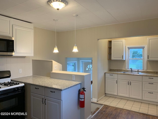 kitchen featuring light hardwood / wood-style flooring, white cabinetry, sink, white gas range oven, and pendant lighting