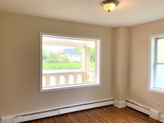 unfurnished room with a baseboard heating unit and dark wood-type flooring