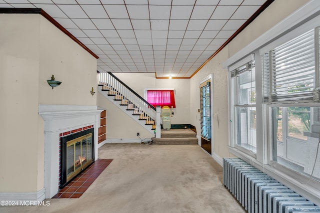 carpeted living room featuring radiator heating unit and ornamental molding