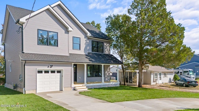 view of front facade featuring a garage, a front lawn, and covered porch