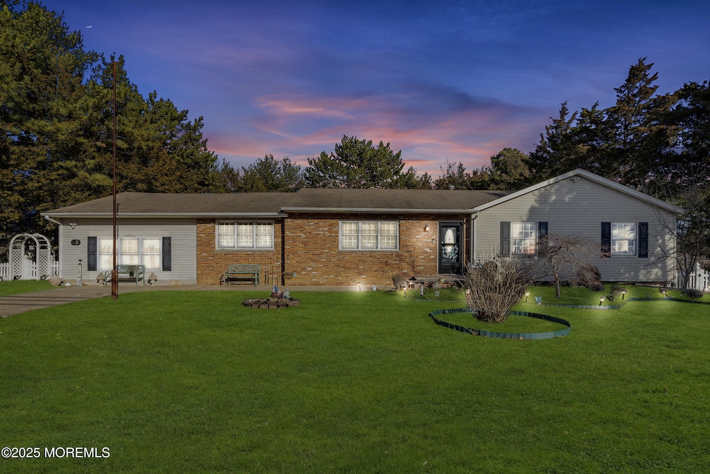 ranch-style home with a yard