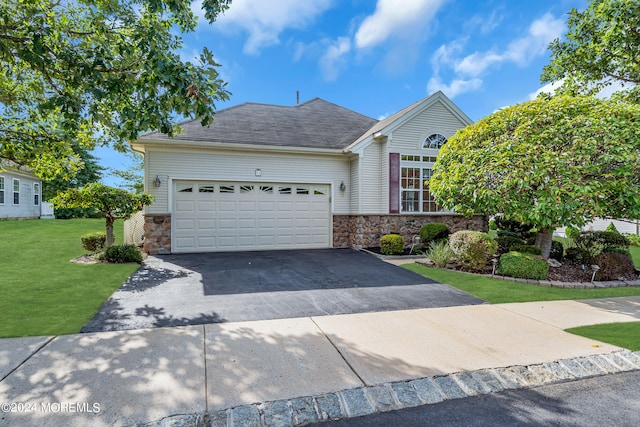 view of front of home with a front yard and a garage